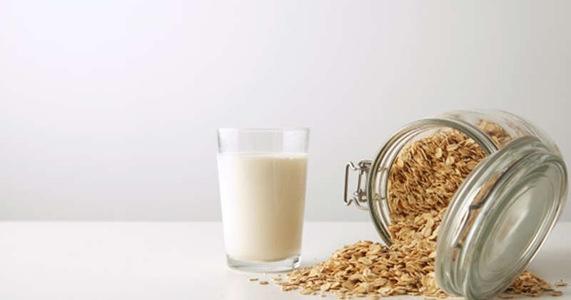 Glass of Oat Milk Alongside a Jar of Oats | Benefits of Oat Milk